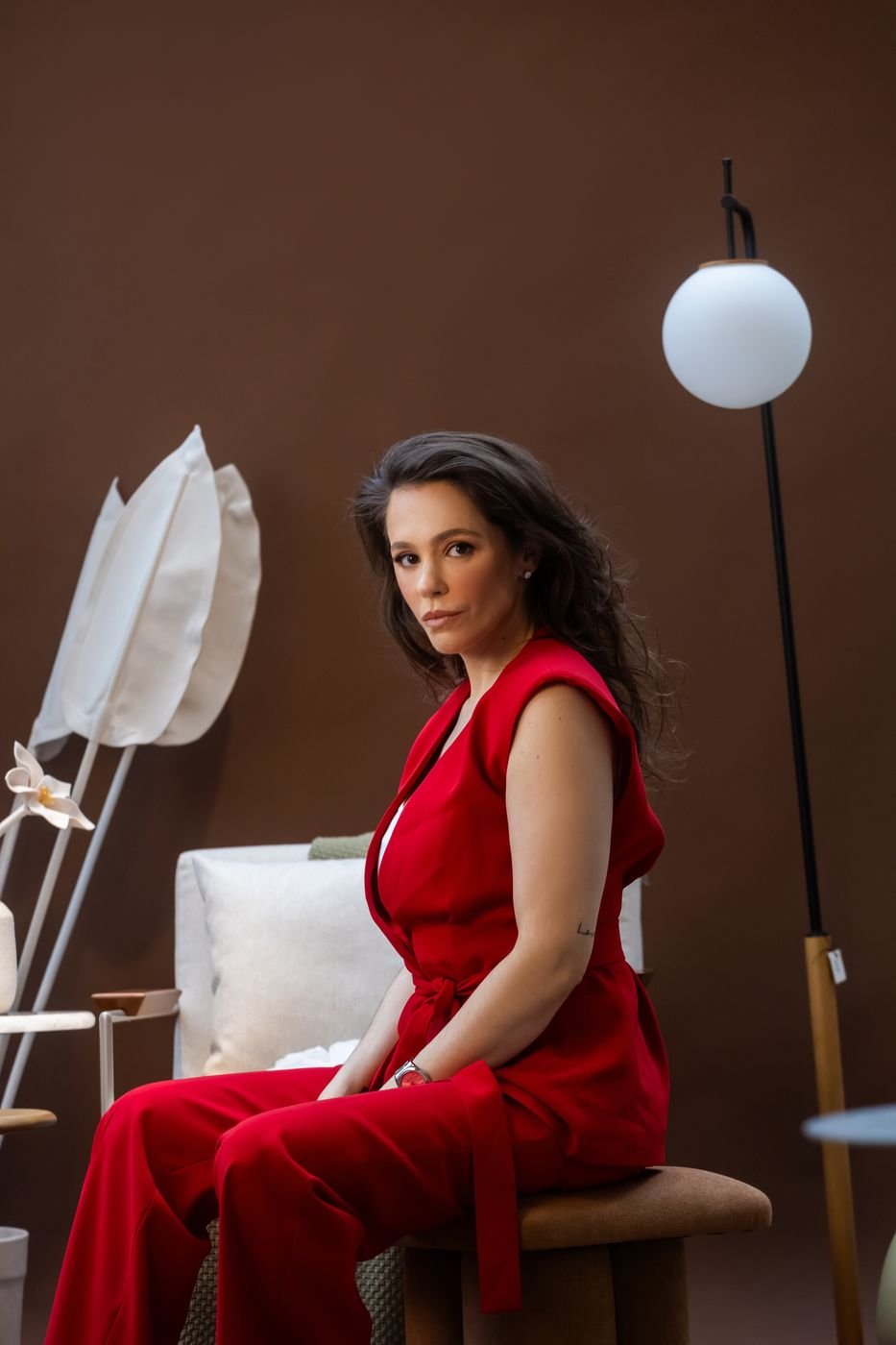 Portfólio da Ingrid: retrato de uma cliente sentada, de macacão vermelho