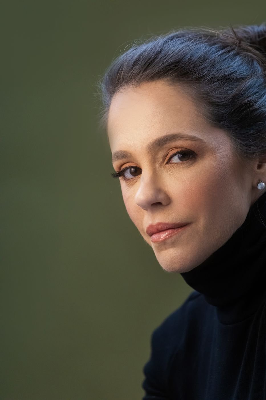 Portfólio da Ingrid: retrato de perfil de uma cliente, em fundo verde